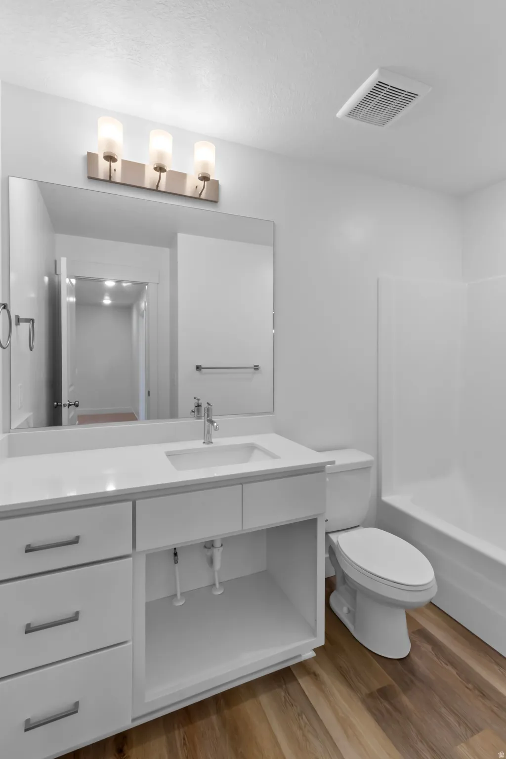 Contemporary bathroom featuring a white vanity with integrated sink, chrome faucet, and coordinating hardware