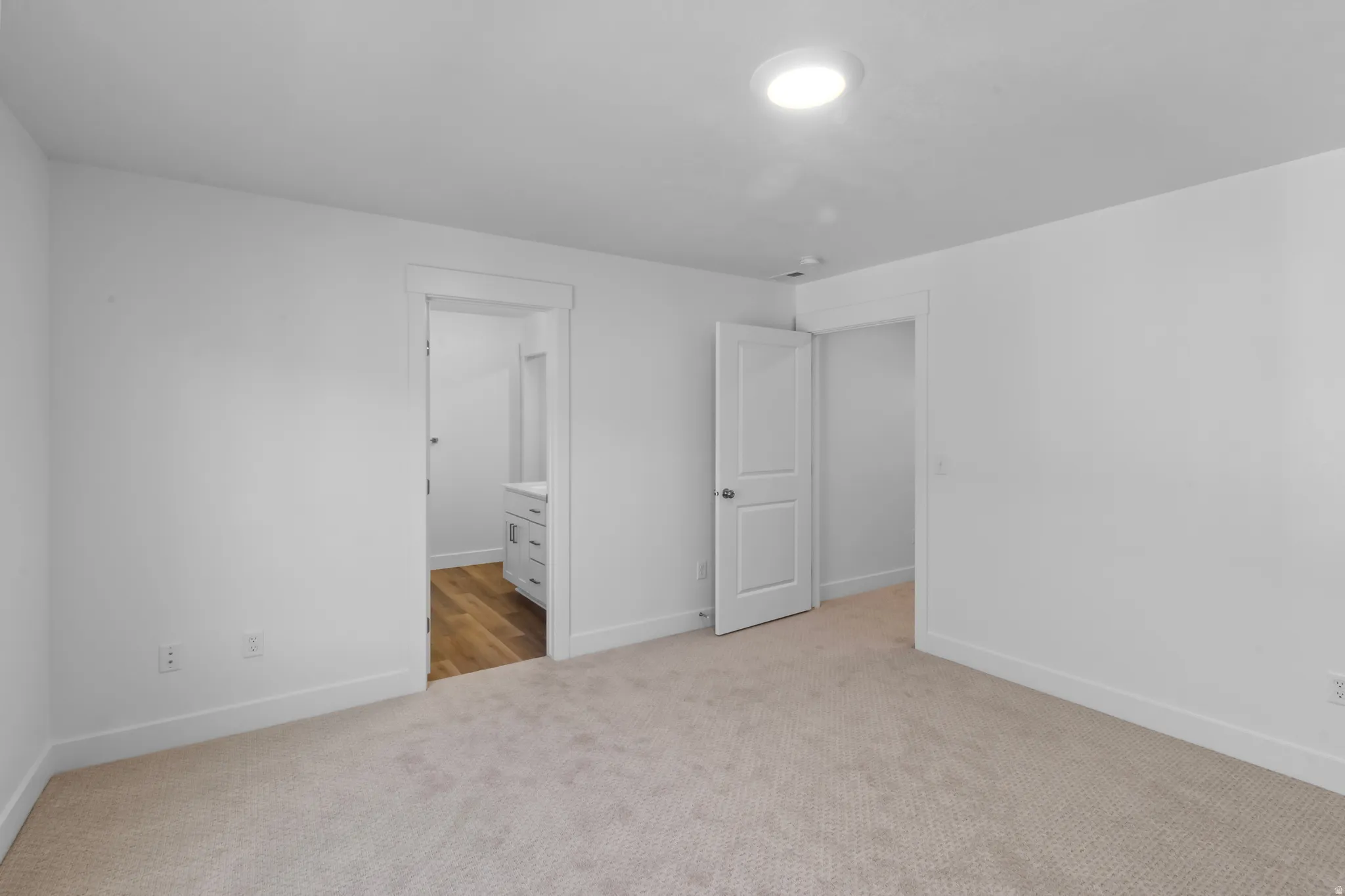 Neutral tone carpeting with white baseboards