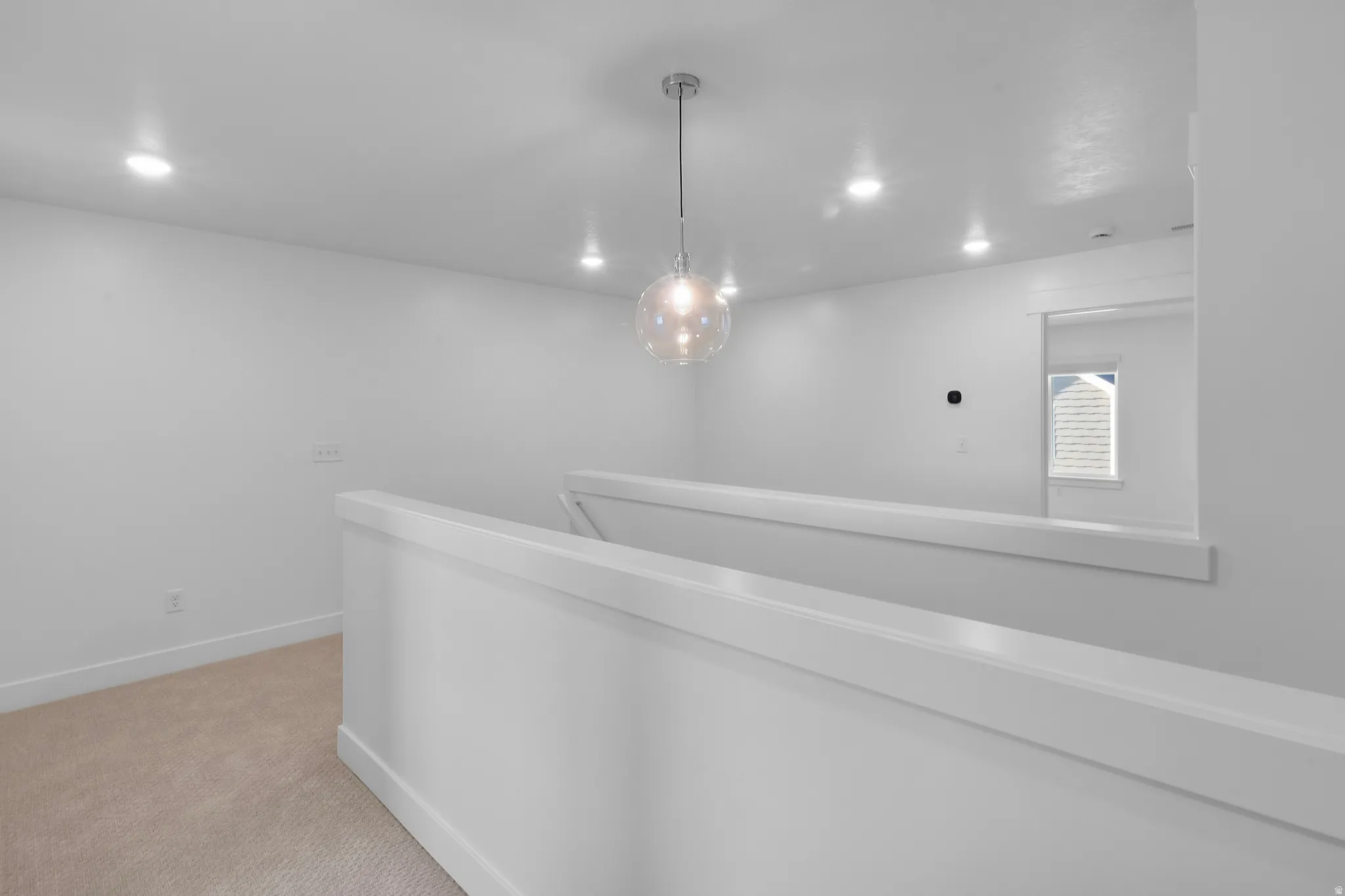 Upper-level landing featuring a modern spherical pendant light and recessed ceiling lights