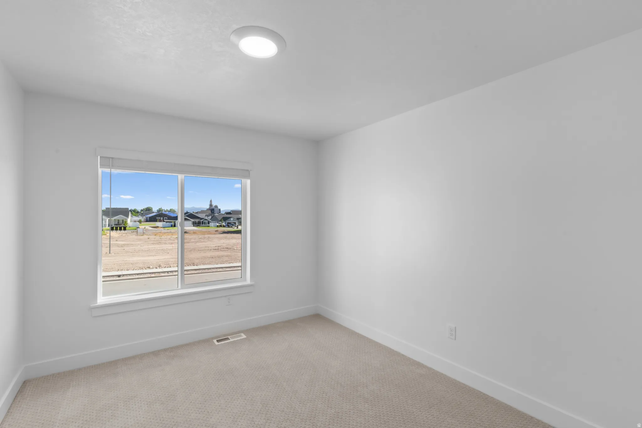 Neutral wall finishes with a large window providing ample natural light