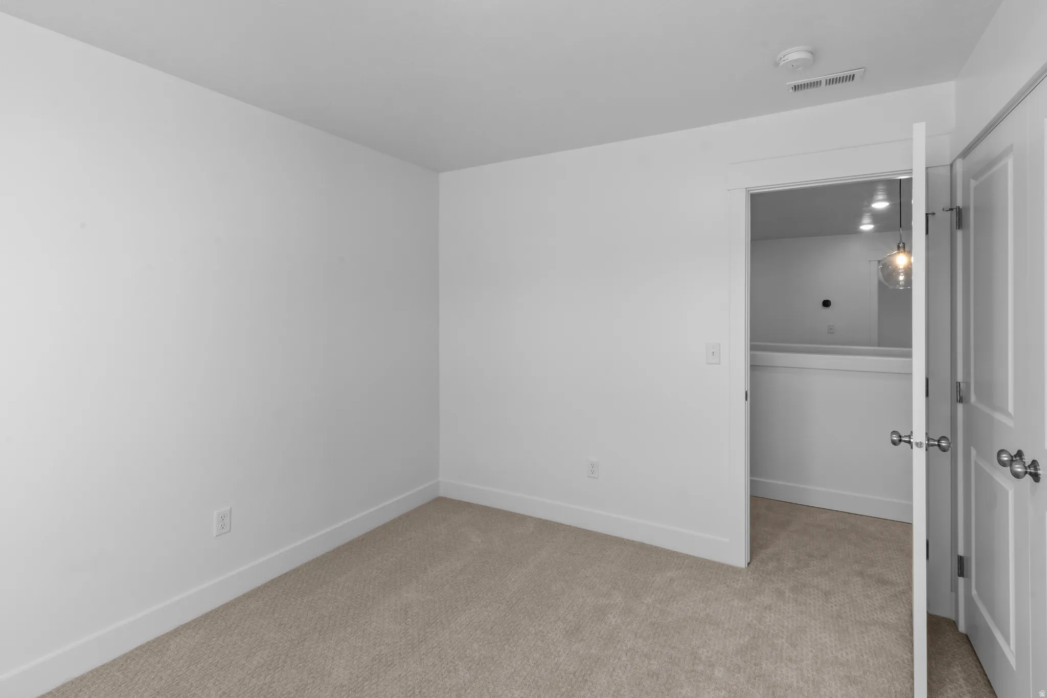 Neutral color palette featuring light-toned carpet flooring and white walls