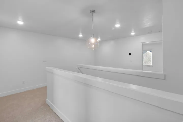 Upper-level landing featuring a modern spherical pendant light and recessed ceiling lights