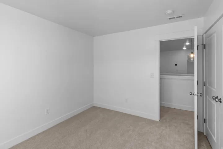 Neutral color palette featuring light-toned carpet flooring and white walls