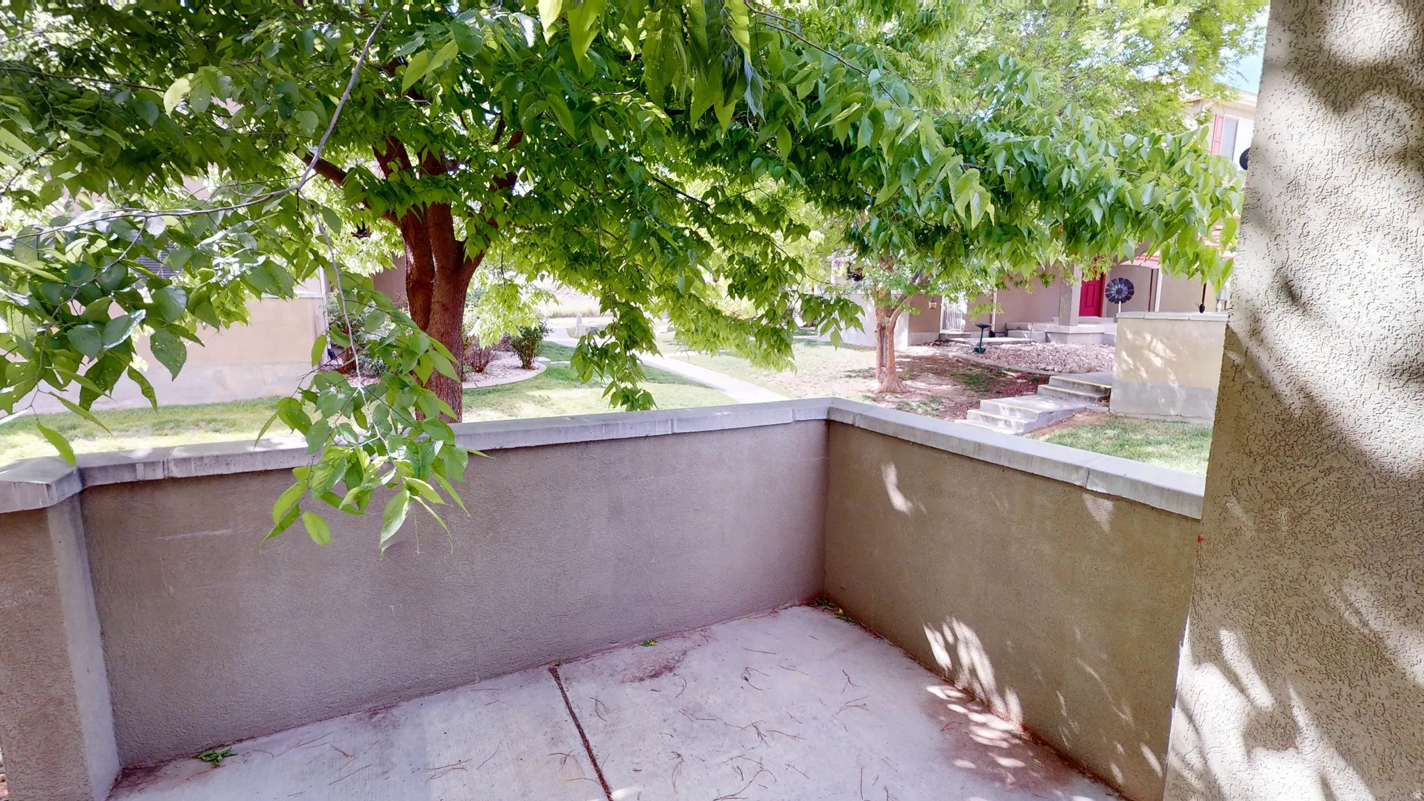 Private patio space featuring solid stucco walls and a concrete floor