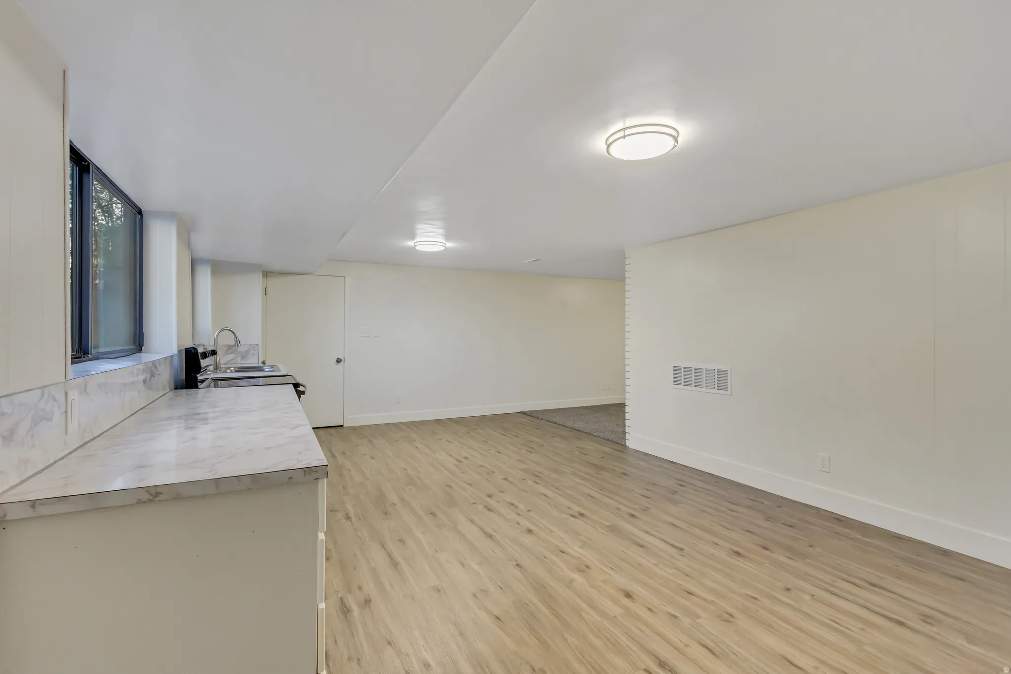 Spacious room featuring light wood-finish flooring
