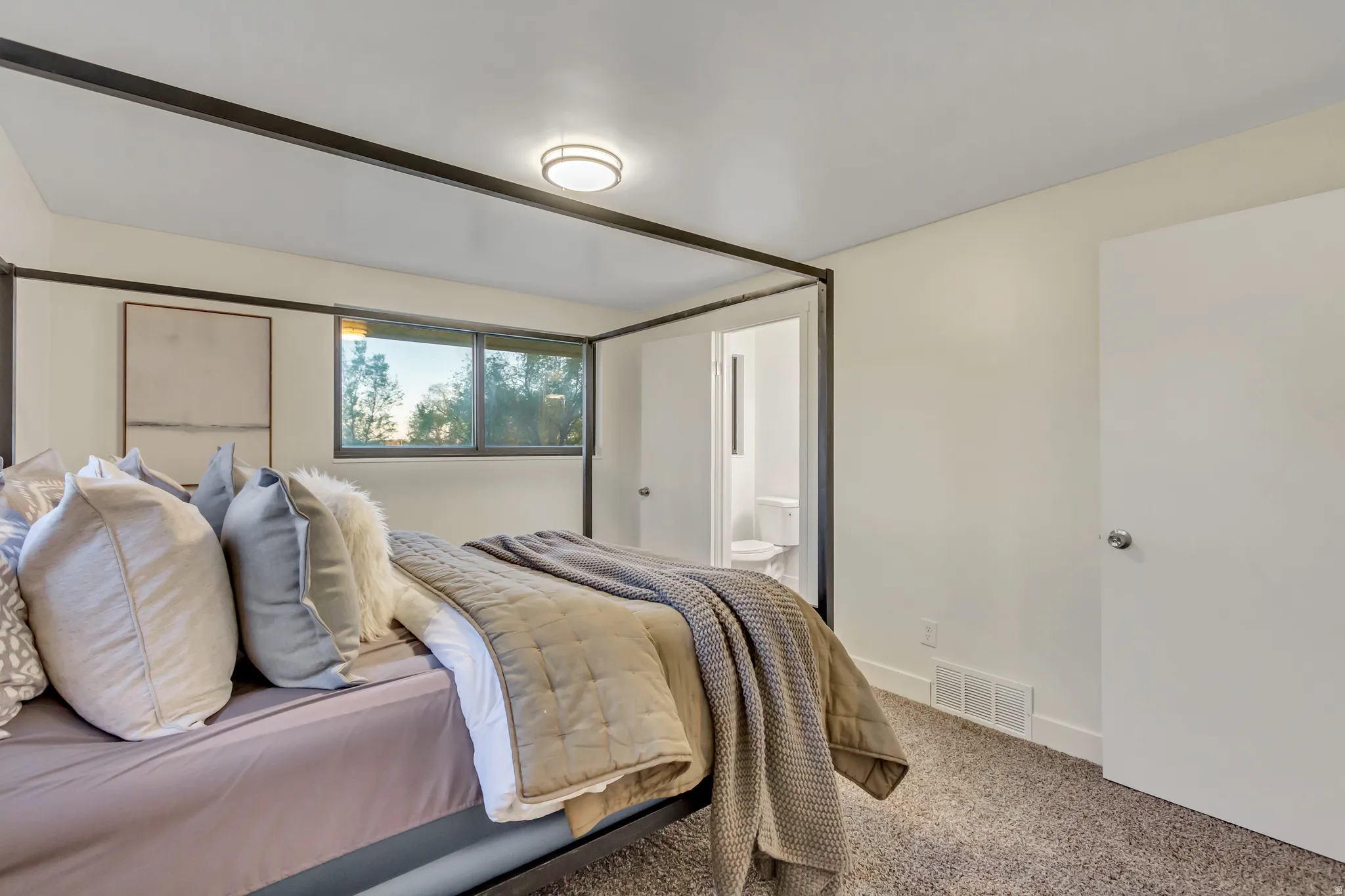 Bedroom featuring a single window, white walls, and dark carpeting