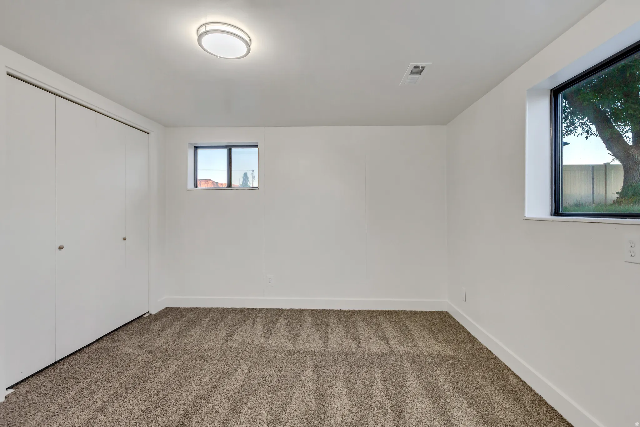 Room featuring neutral tone carpeting and crisp white walls