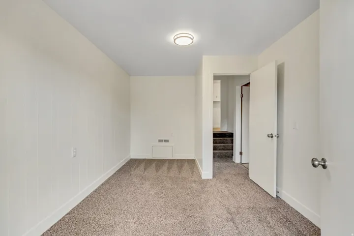 Neutral color palette room with light beige carpet flooring and white baseboards