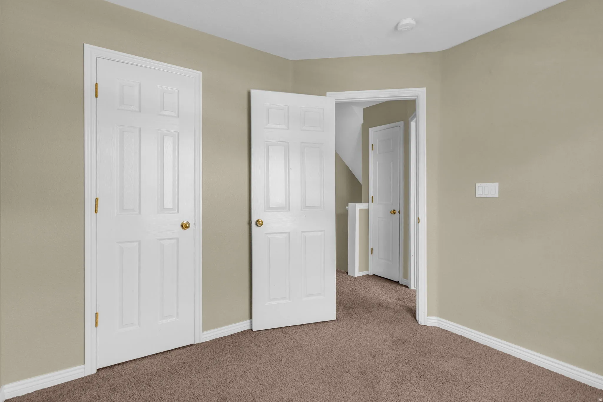 Carpeted room with neutral wall color and white trim