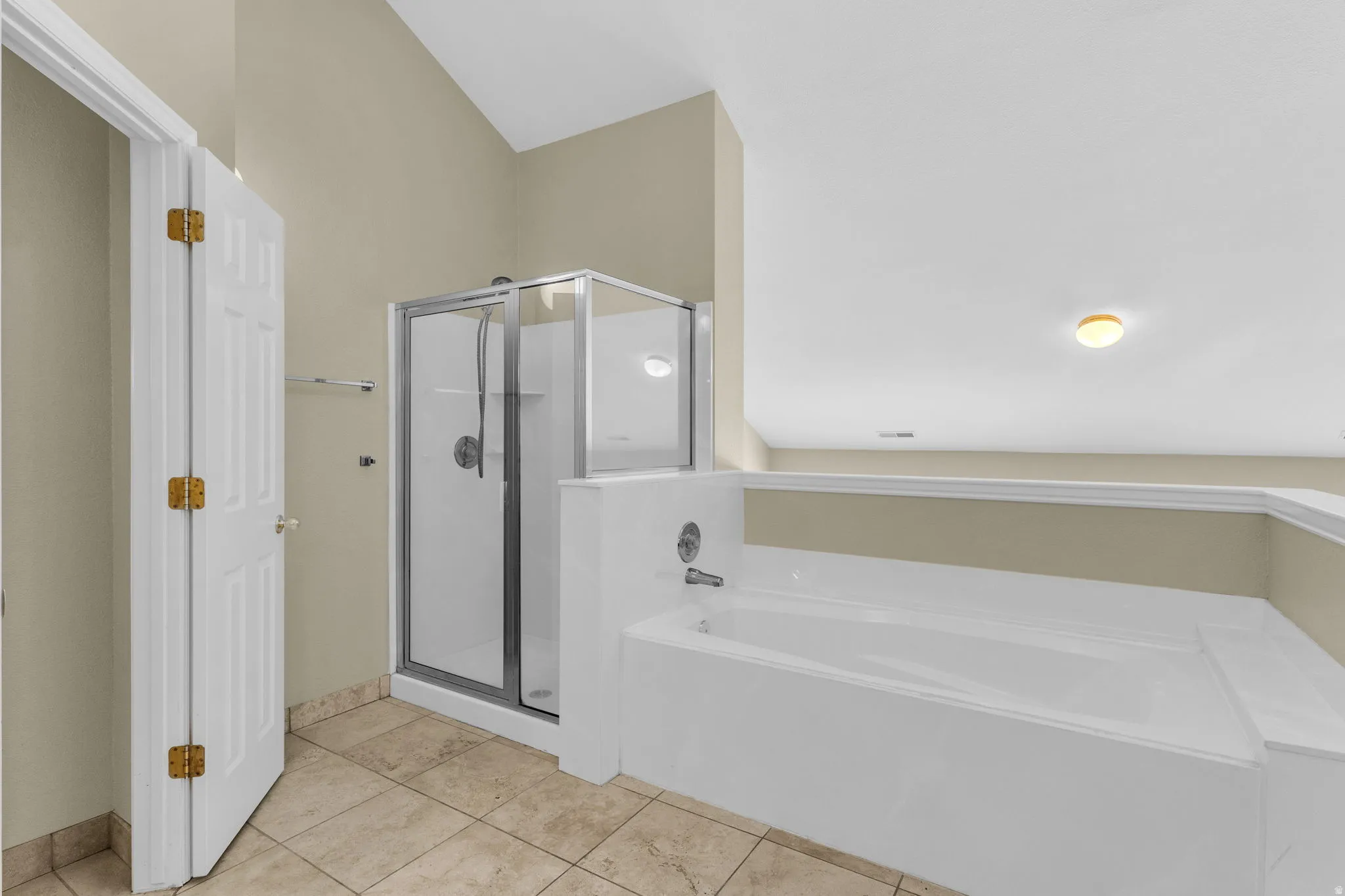 Bathroom featuring an enclosed shower, a built-in tub with chrome fixtures, and neutral-toned wall paint