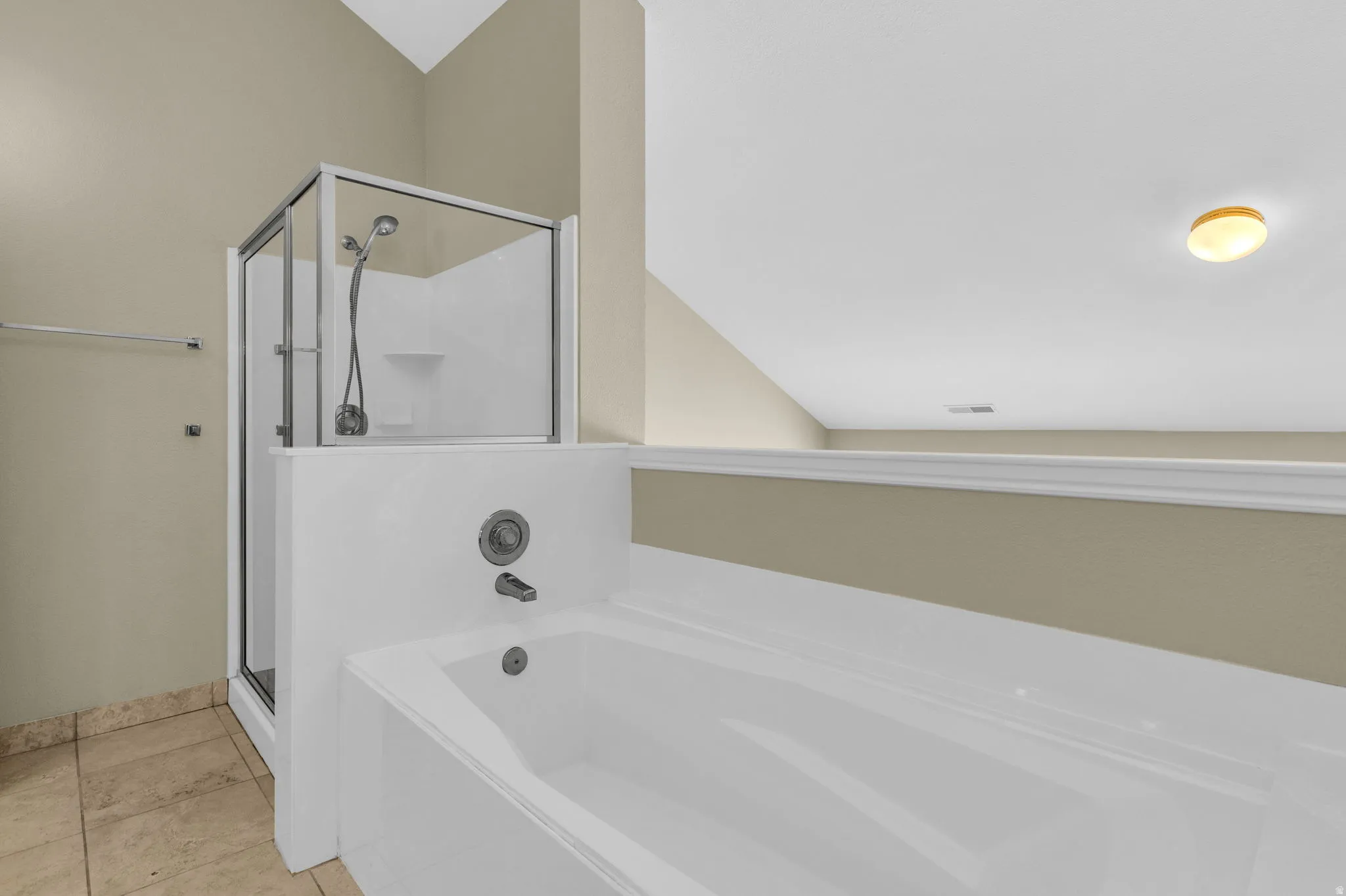 Soaking tub with integrated shower system featuring a glass enclosure