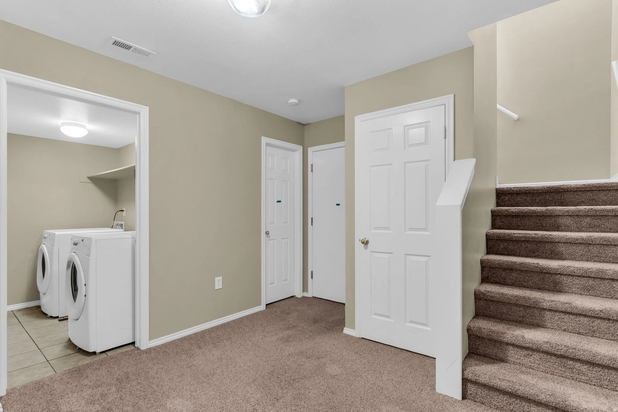 Dedicated laundry area featuring a utility sink and tiled flooring