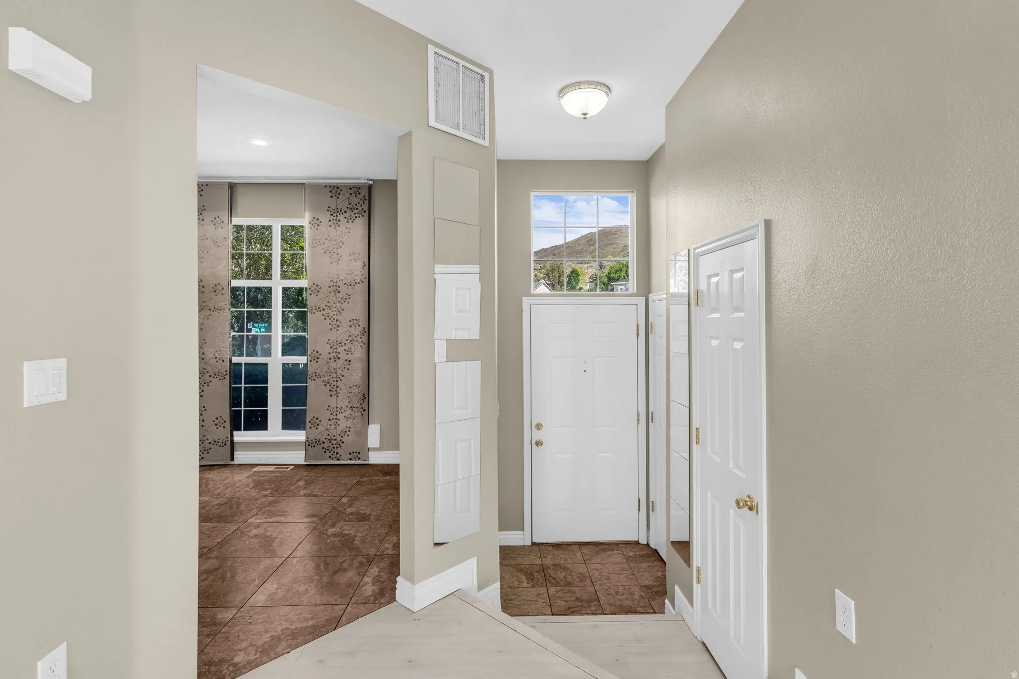 Entryway featuring neutral wall tones and a transom window with mountain scenery