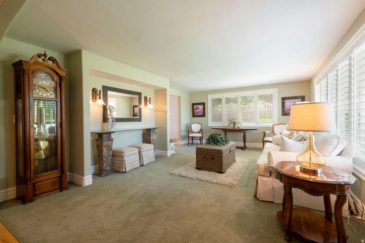 Spacious living area featuring soft green carpeting and a neutral wall palette