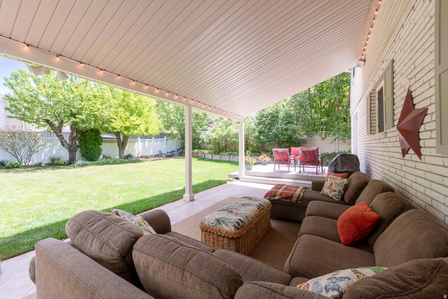 Covered patio with a tile surface and white brick exterior