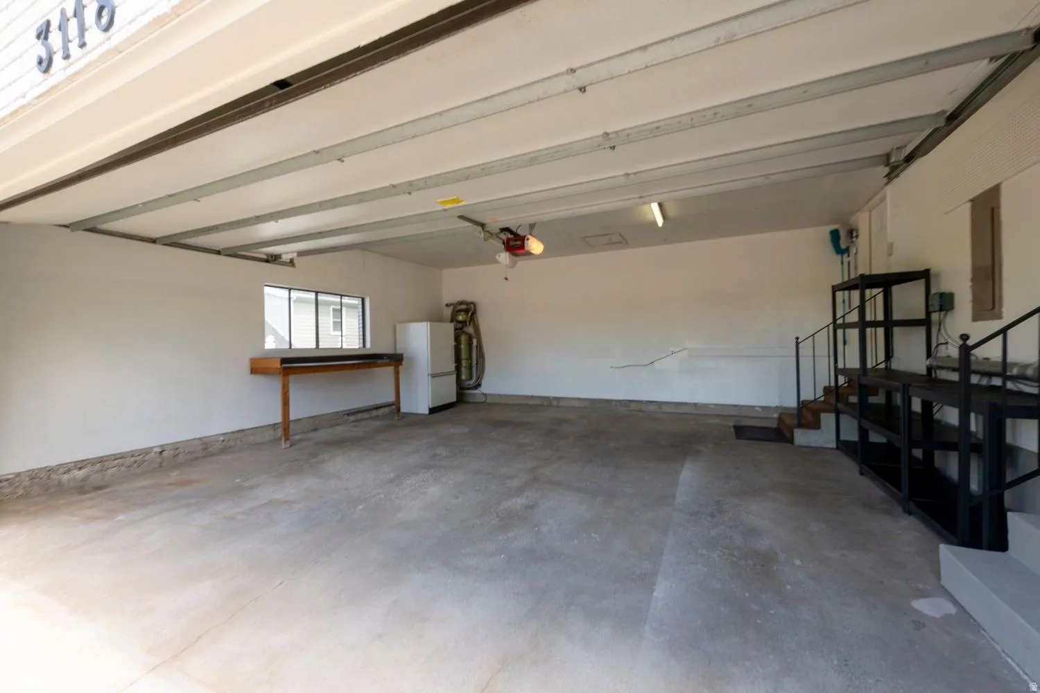 Spacious garage featuring concrete flooring and a window providing natural light