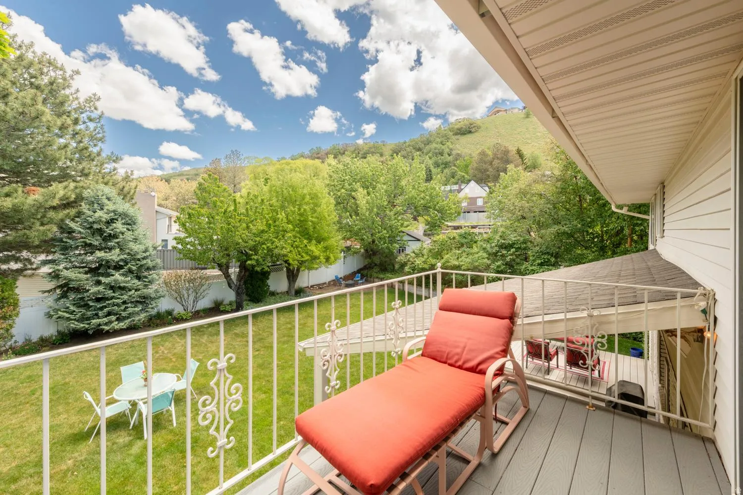 Private balcony with painted wood-finish decking and white metal railing