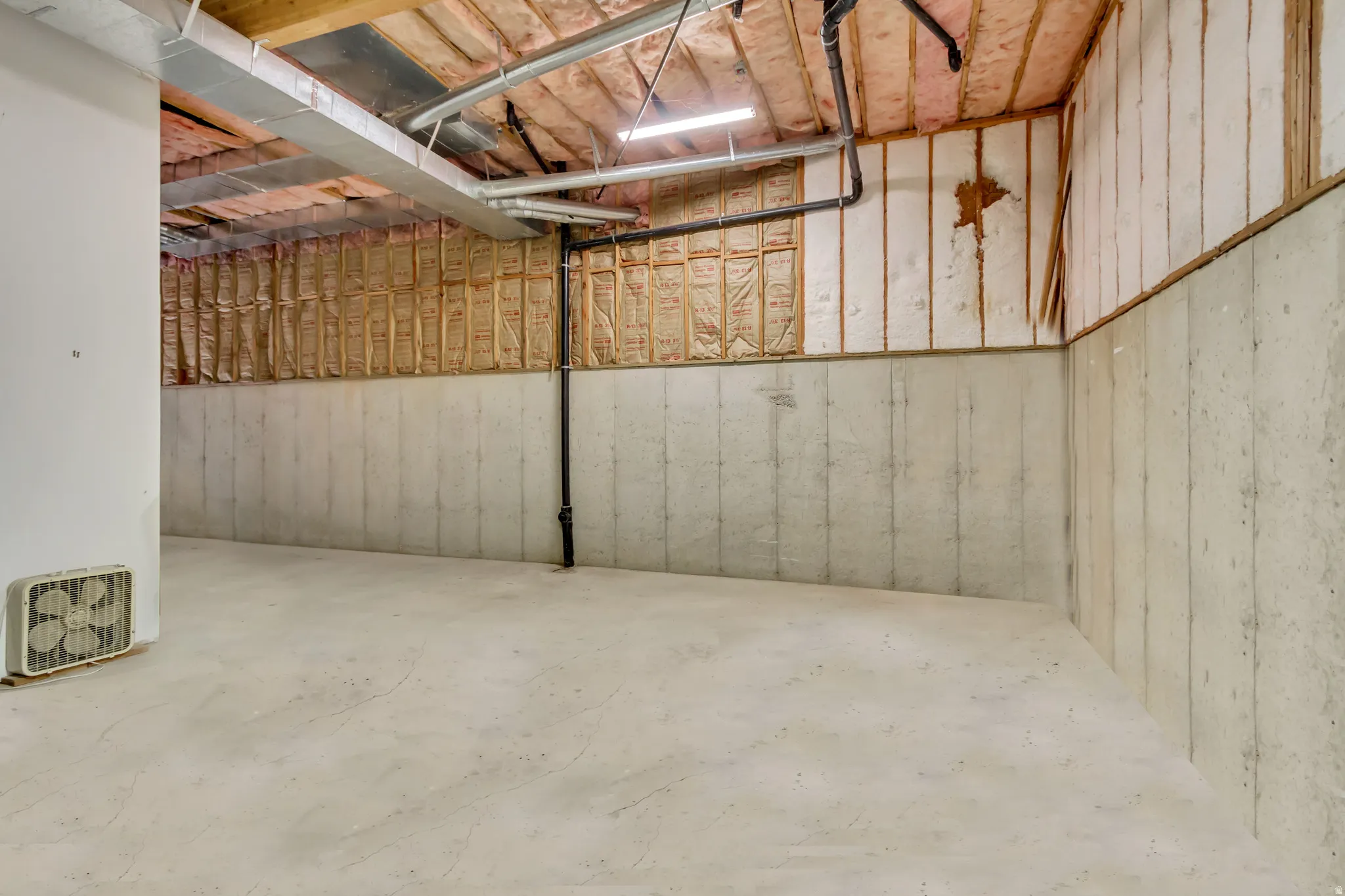 Unfinished basement featuring concrete foundation walls and exposed ceiling joists