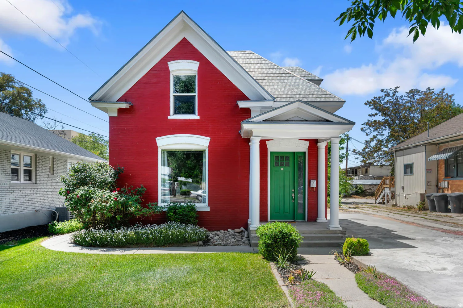 Red brick exterior with white trim, featuring a prominent front gable and a covered entry porch