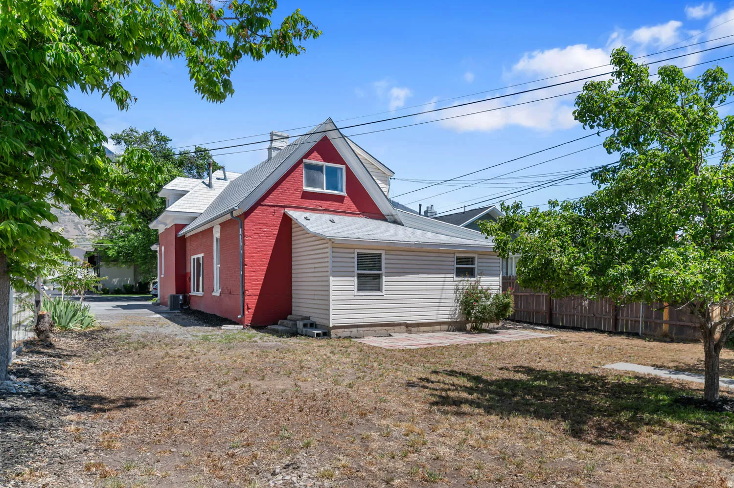 Red brick and light-toned siding exterior with a contrasting gray roof