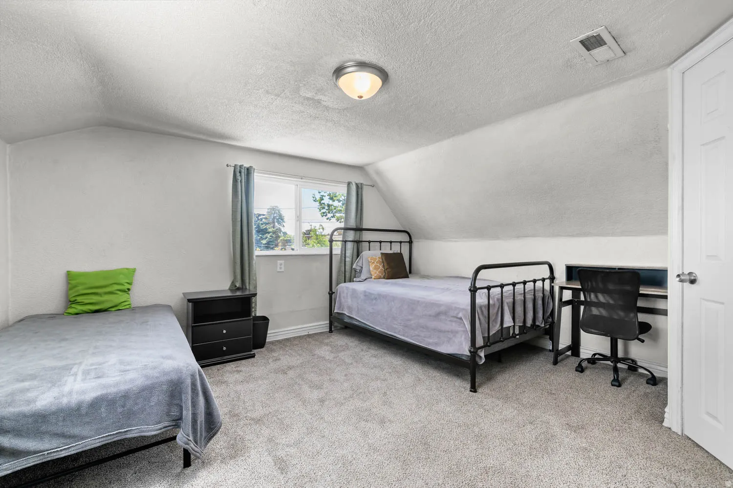 Room featuring neutral carpeting, sloped ceilings, and a window with natural light
