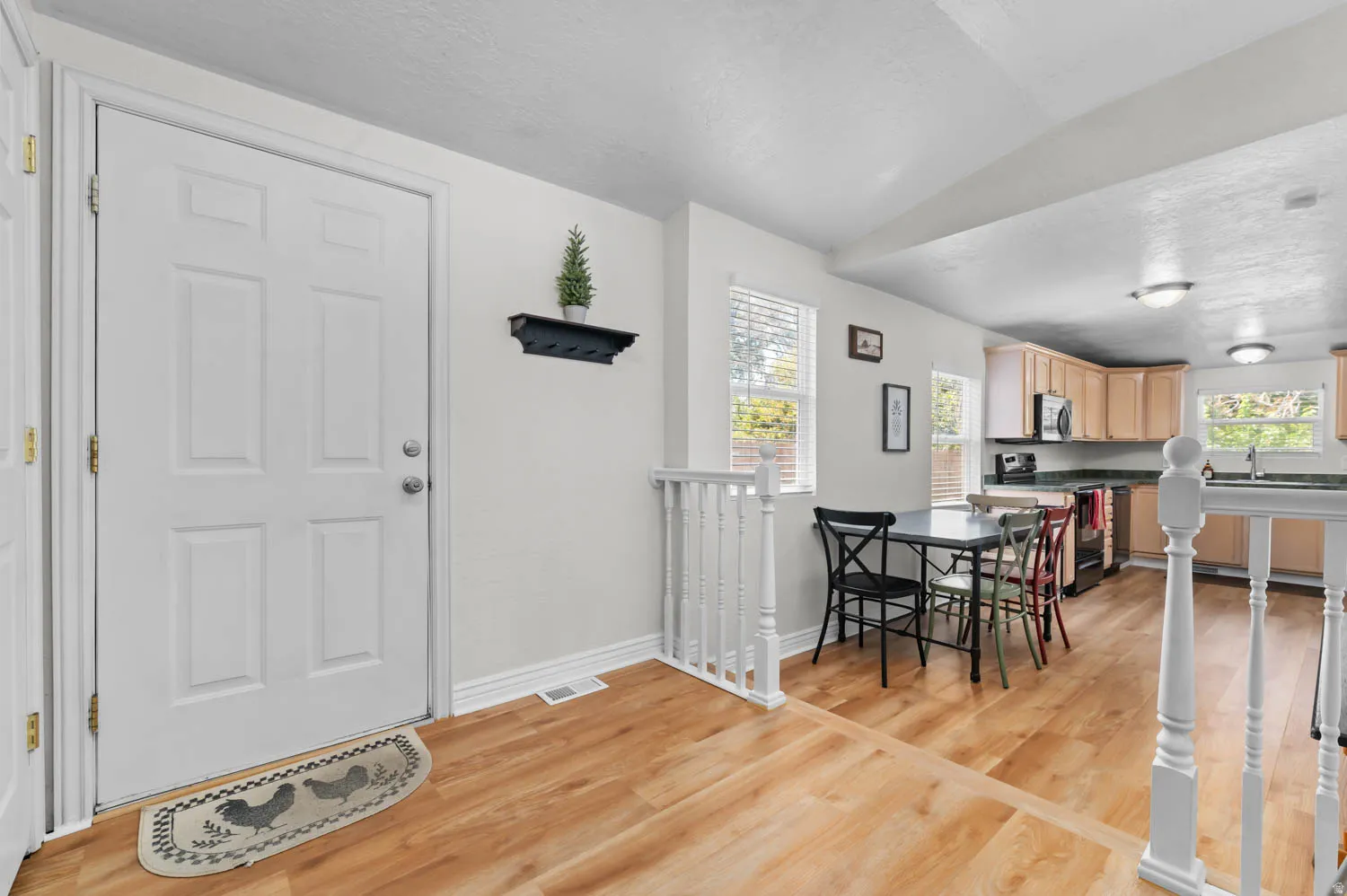 Entryway featuring a white paneled door, wood-finish flooring, and white baseboards