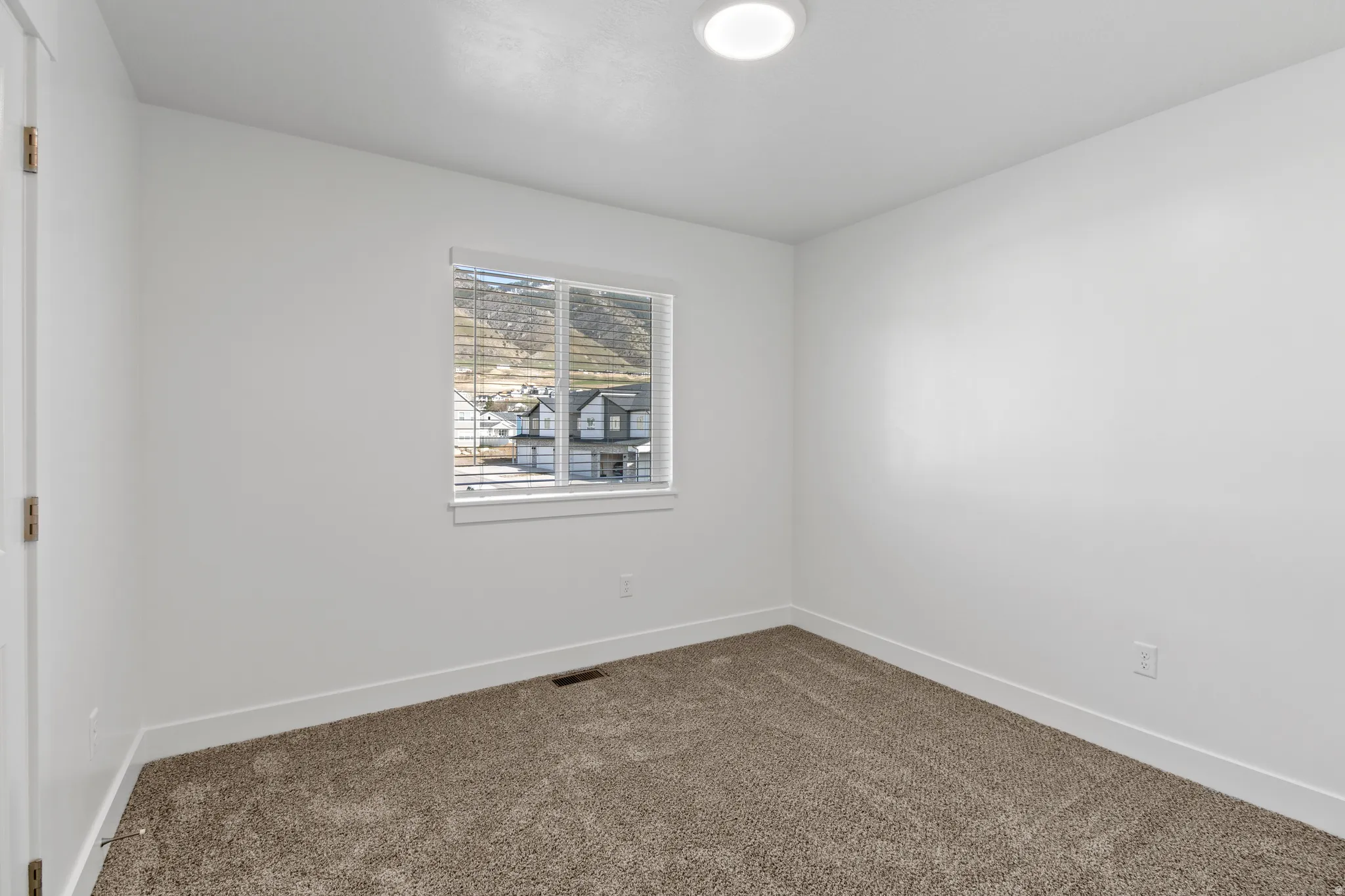 Neutral wall colors with white trim and a single window offering a distant mountain backdrop