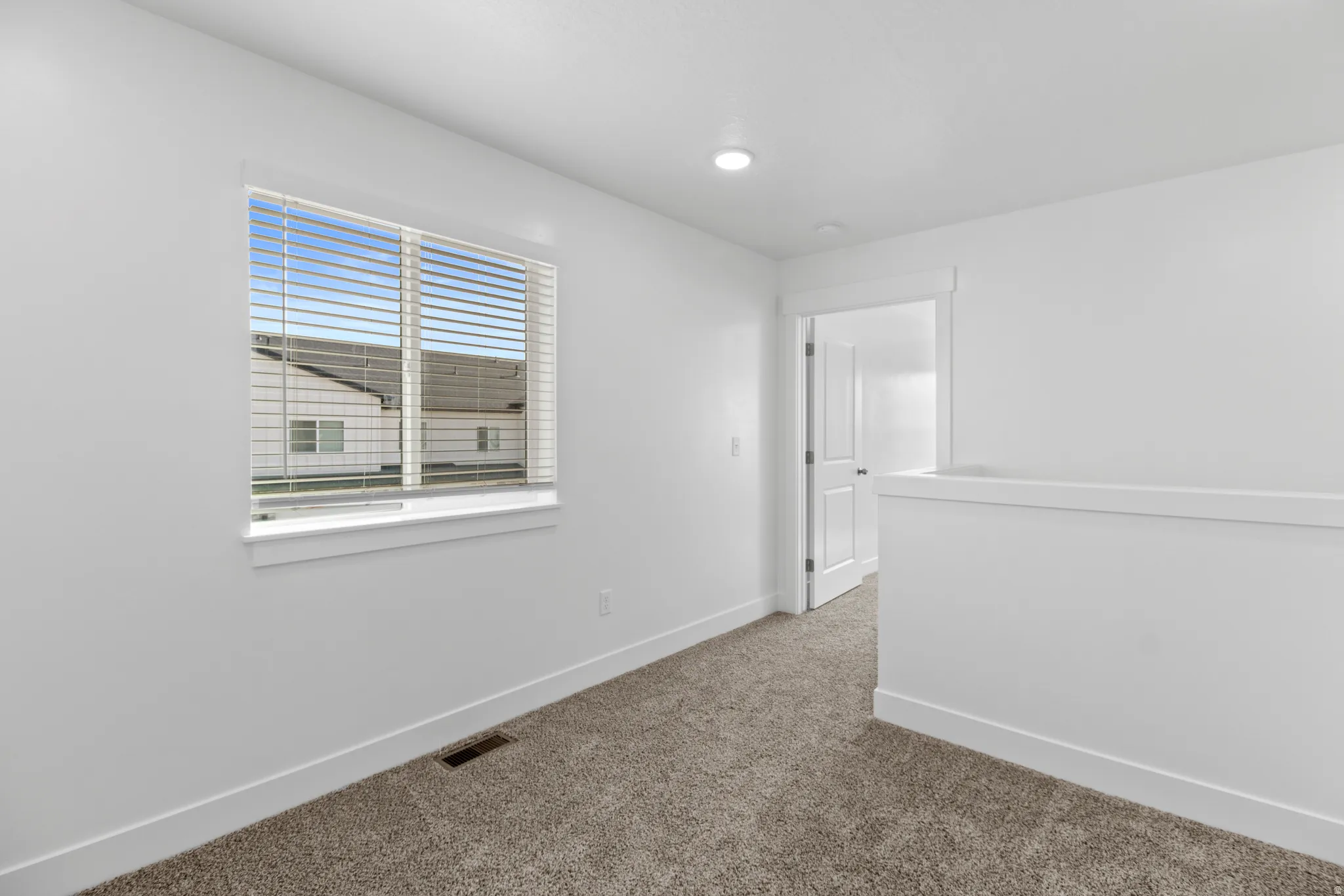 Bright room with neutral wall paint and carpet flooring
