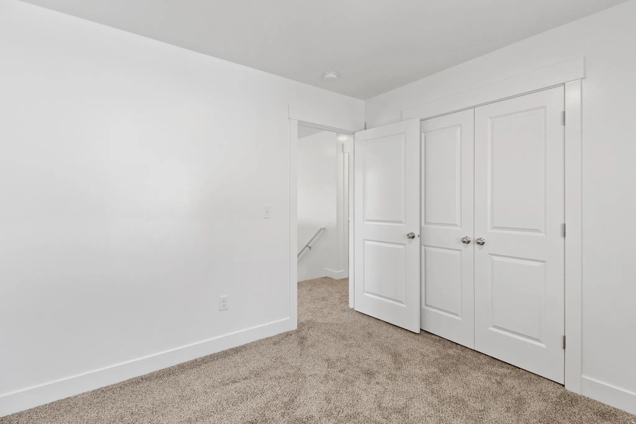 Room featuring neutral-toned carpet, white walls, and bright white trim