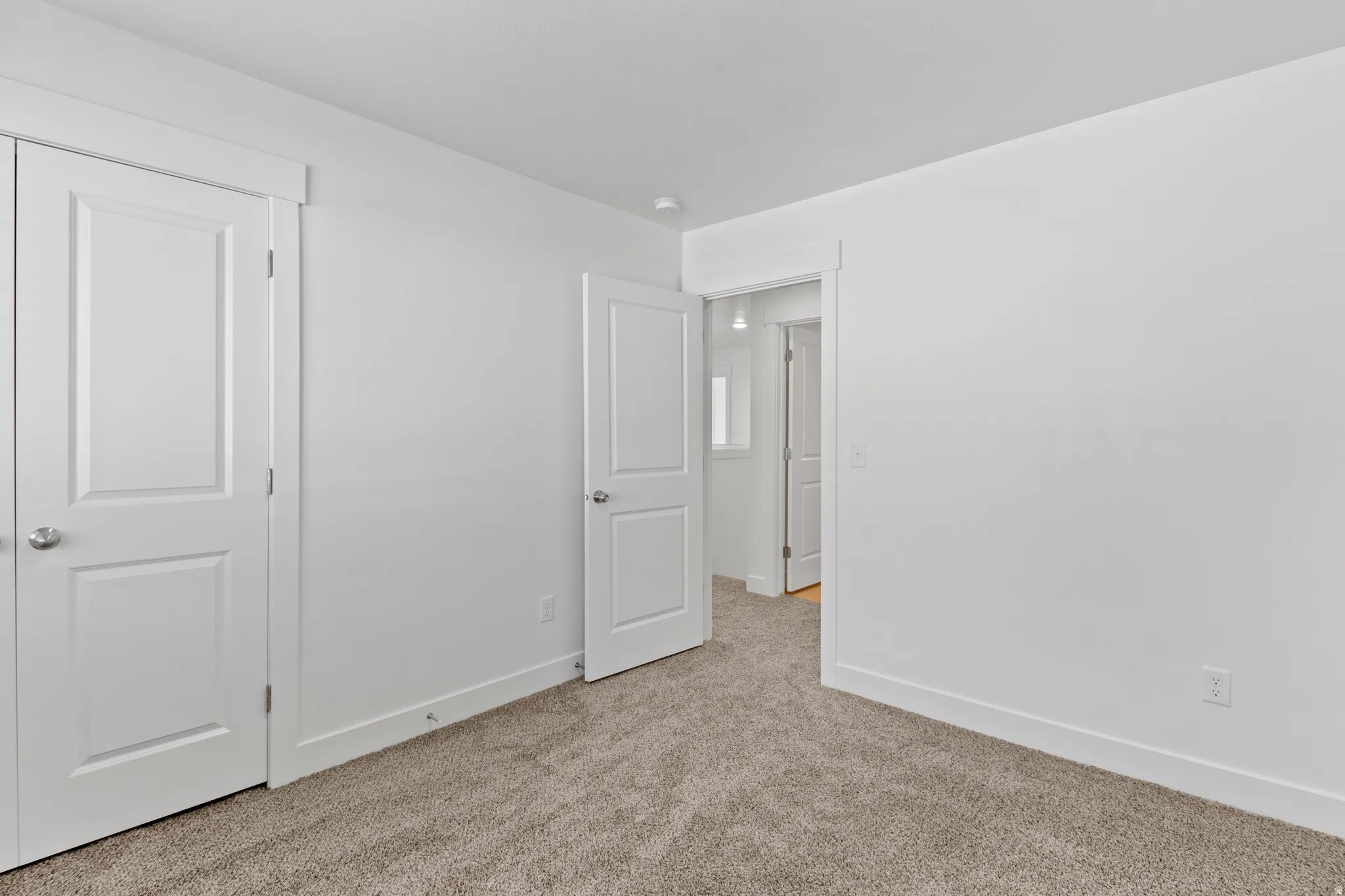 Room featuring neutral carpeting, white walls, and a white trim package