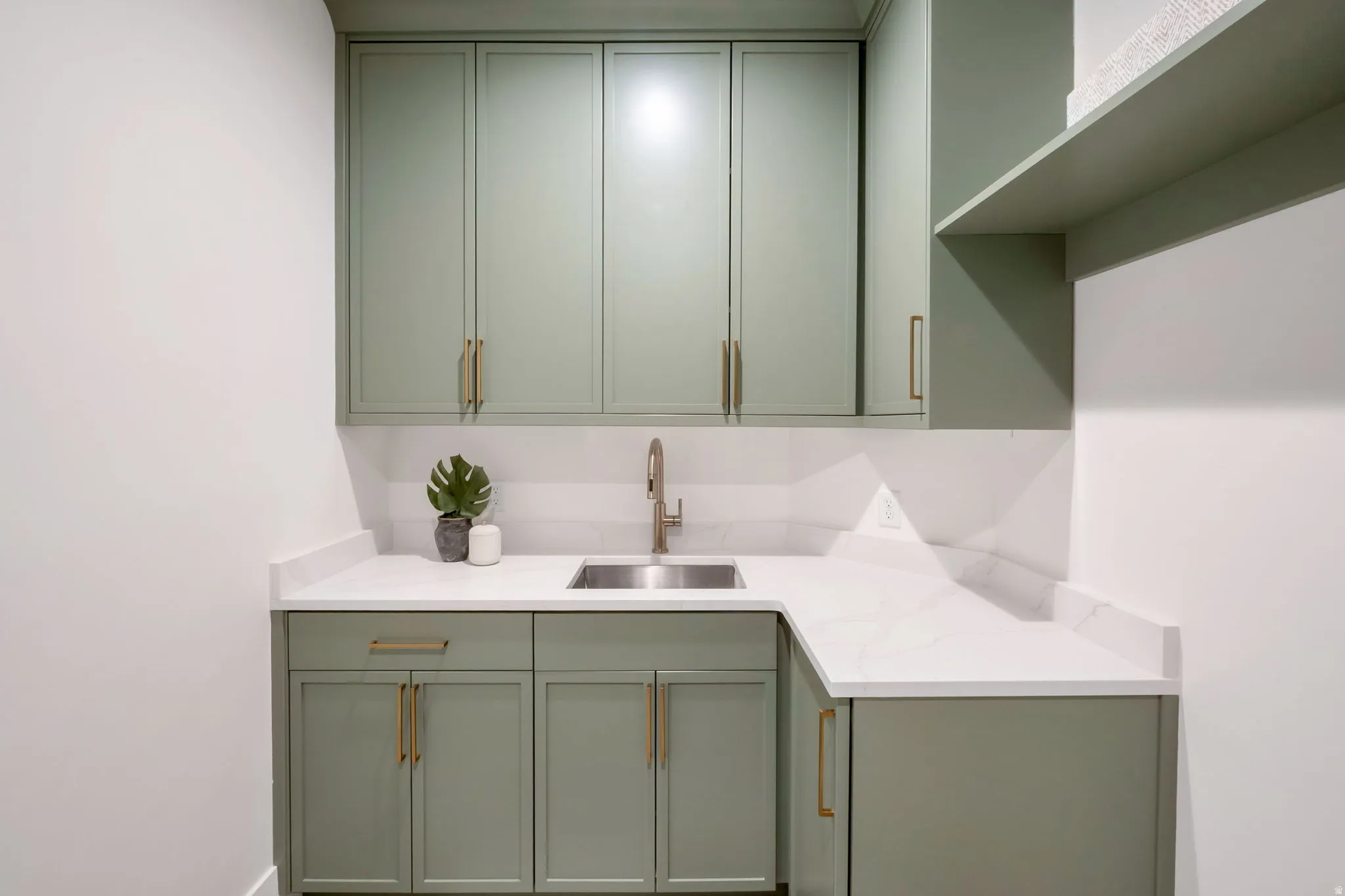L-shaped countertop with an integrated stainless steel sink and brushed nickel faucet