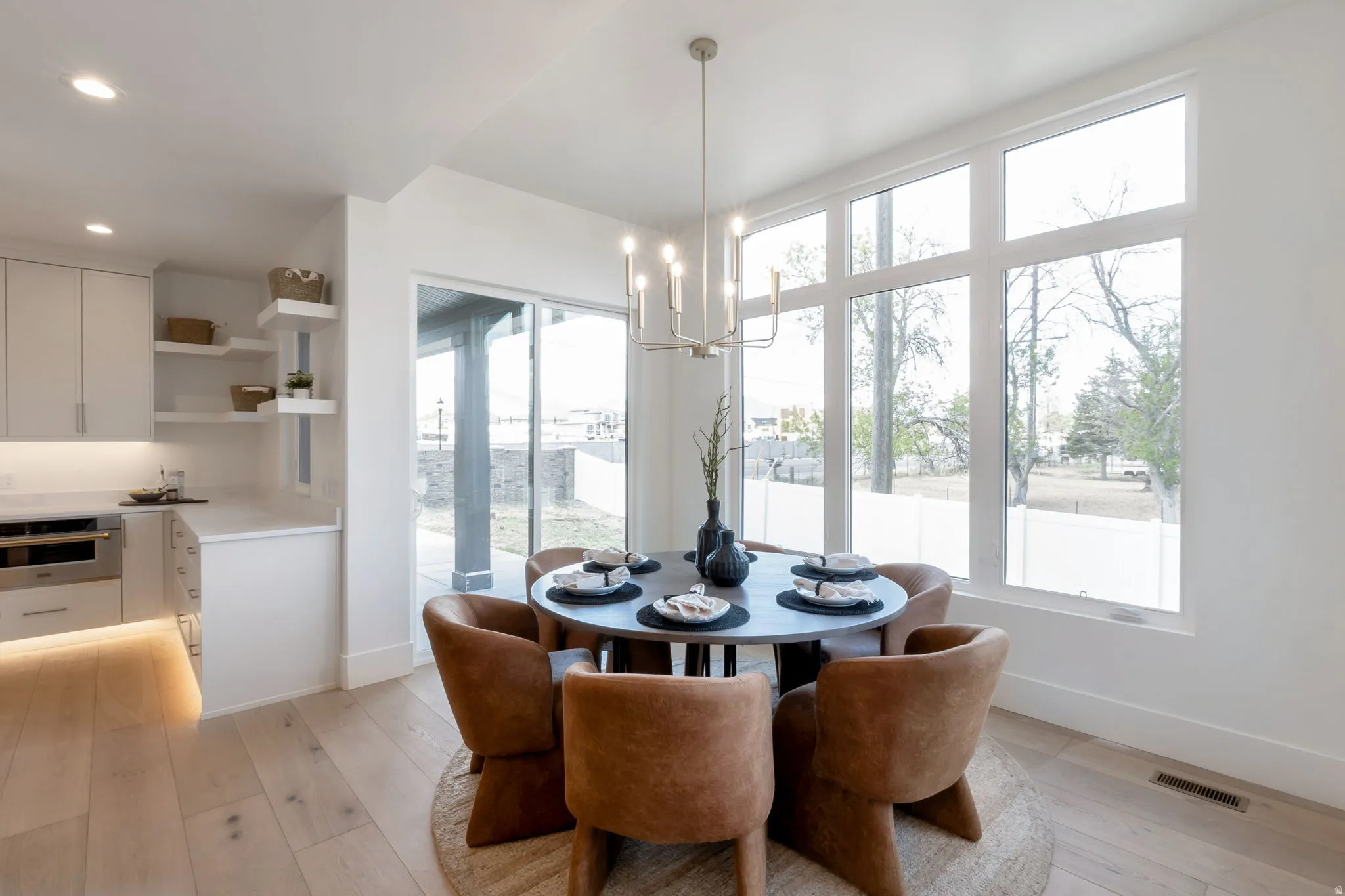 Dining area with a modern chandelier and expansive windows