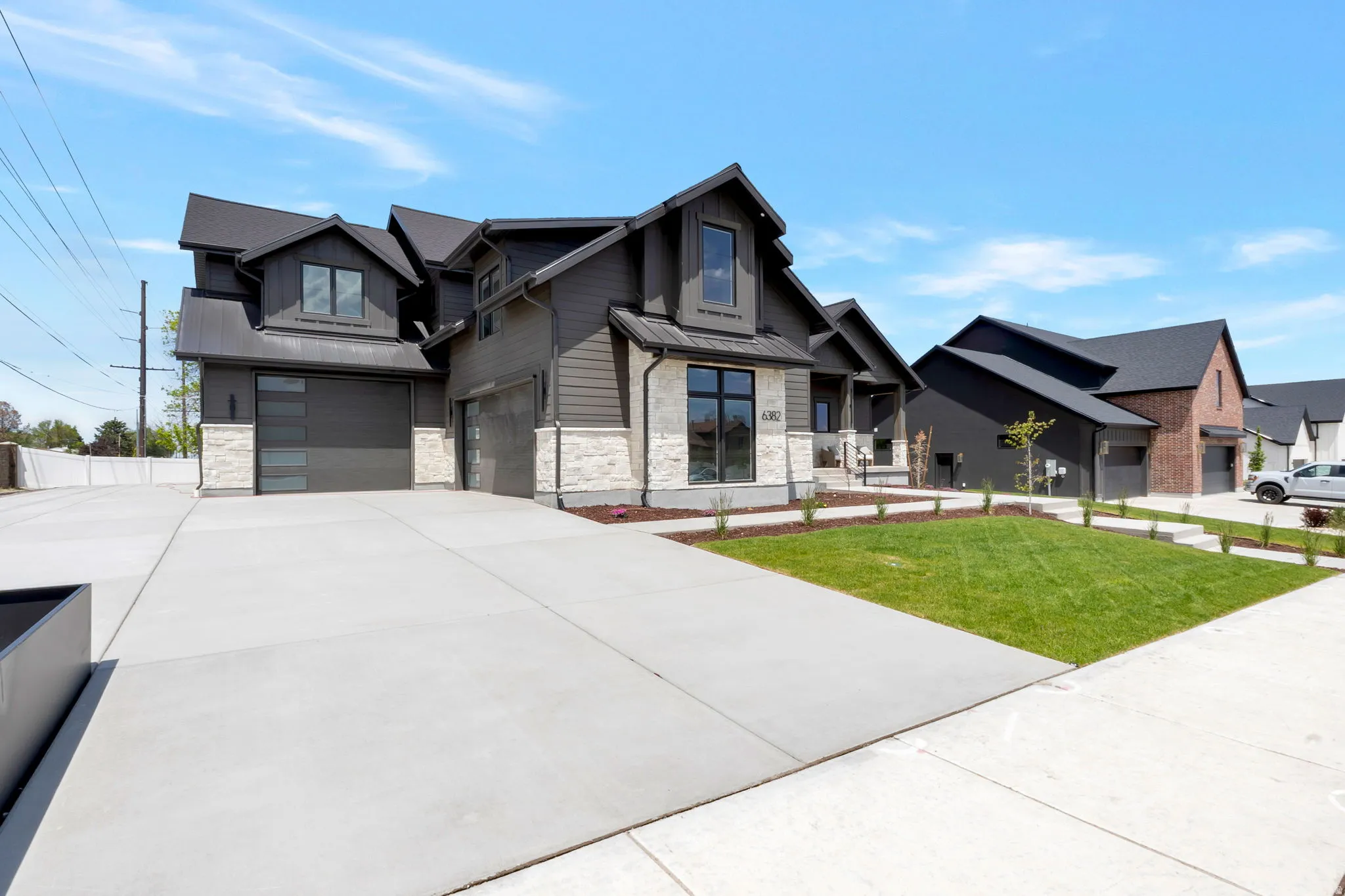 Contemporary exterior featuring dark siding and light stone accents