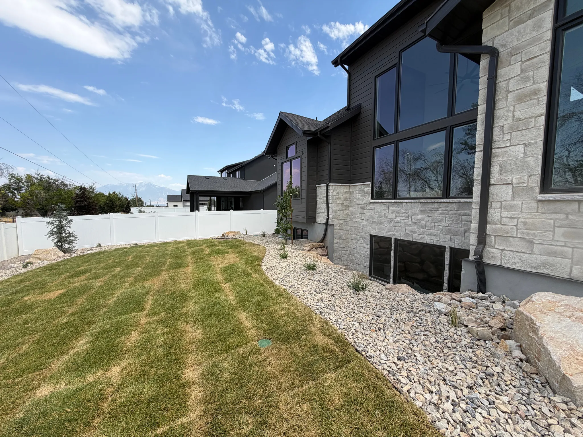 Manicured lawn area with a white privacy fence
