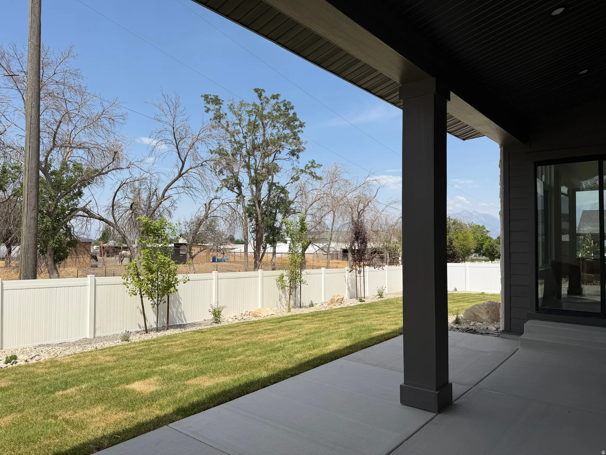 Expansive covered patio with a concrete surface, providing a shaded outdoor living area