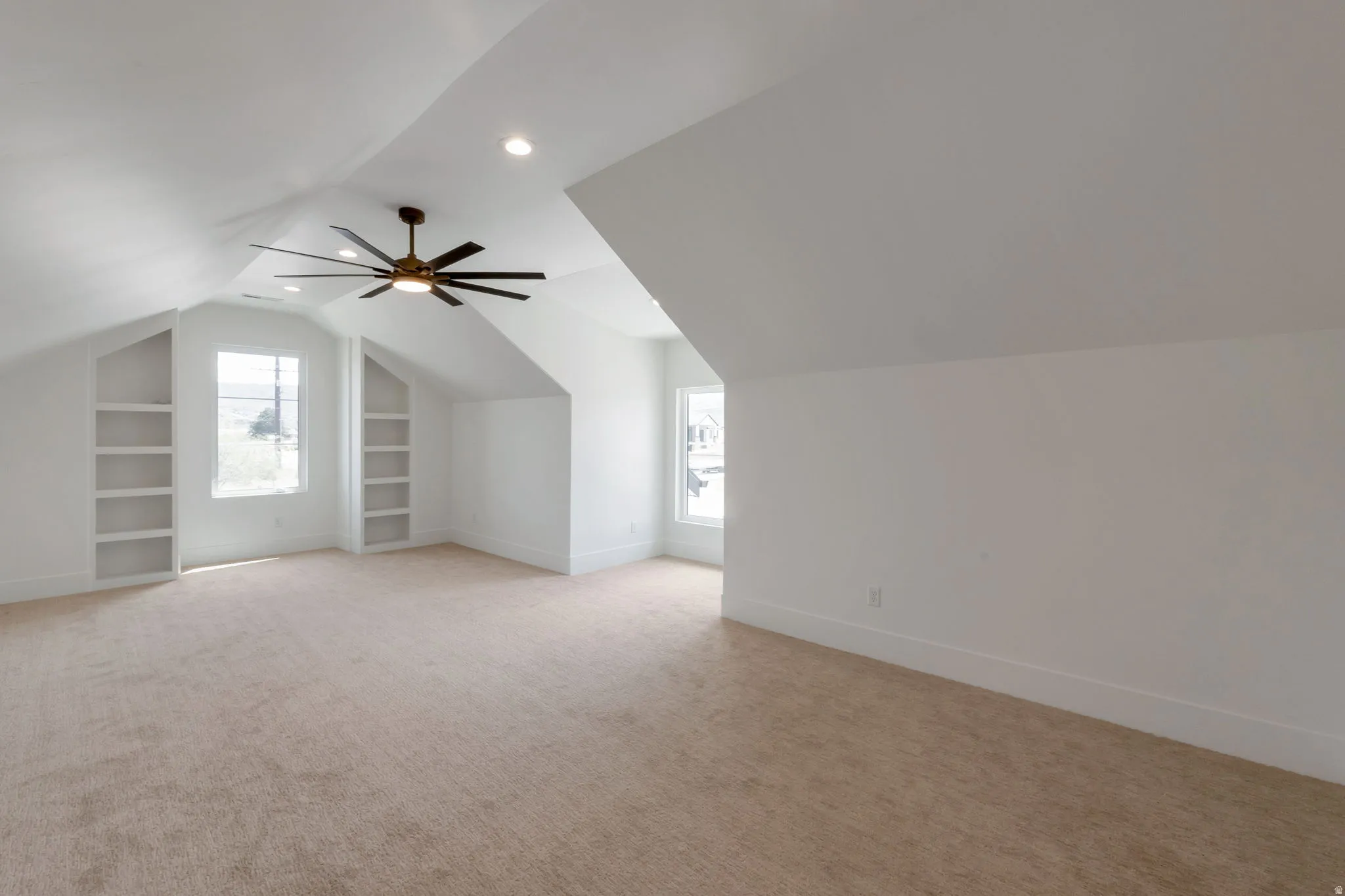 Spacious room featuring vaulted ceilings, recessed lighting, and a contemporary ceiling fan
