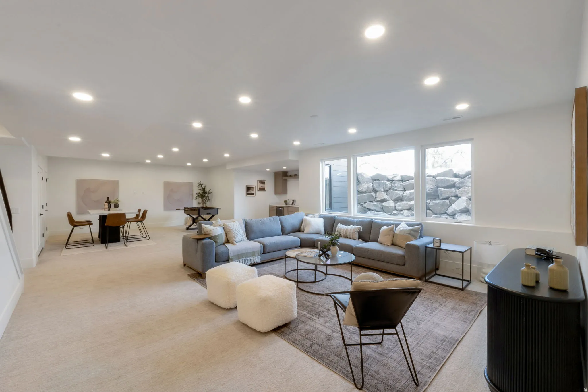 Spacious lower-level living area featuring recessed lighting throughout, white walls, and light-colored carpeting