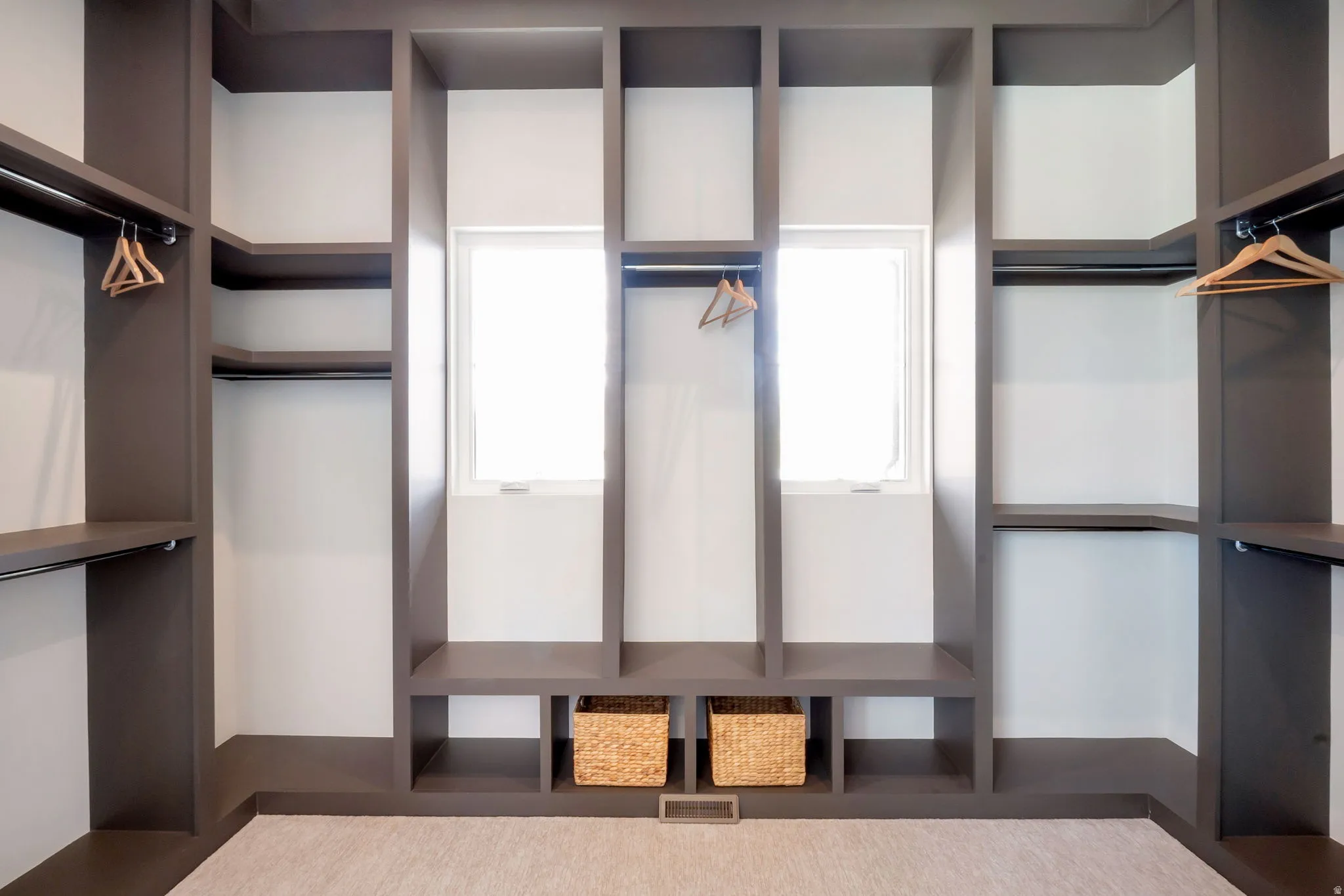 Custom closet system featuring built-in shelving, hanging rods, and integrated window openings