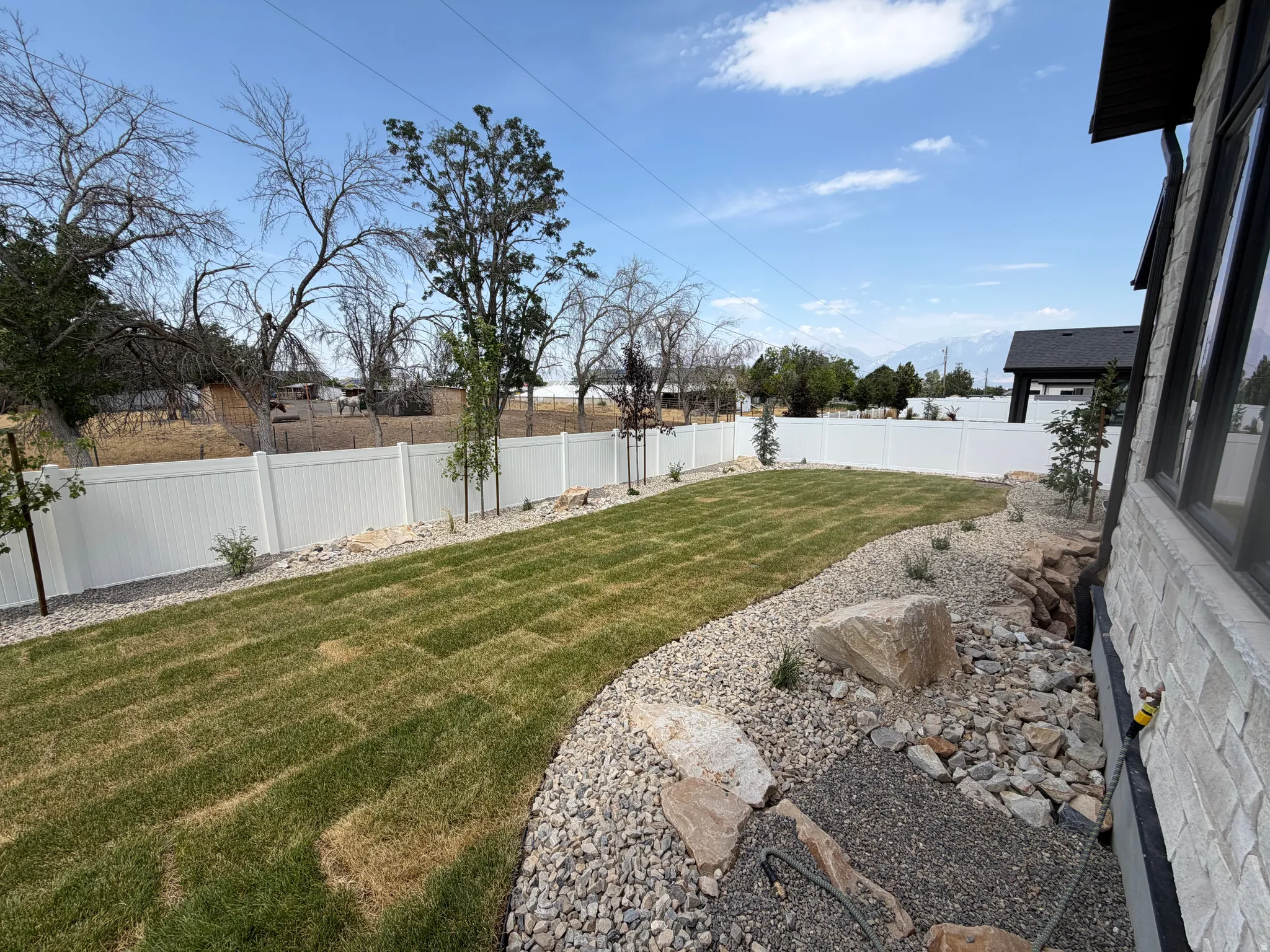 Manicured lawn area with a white privacy fence