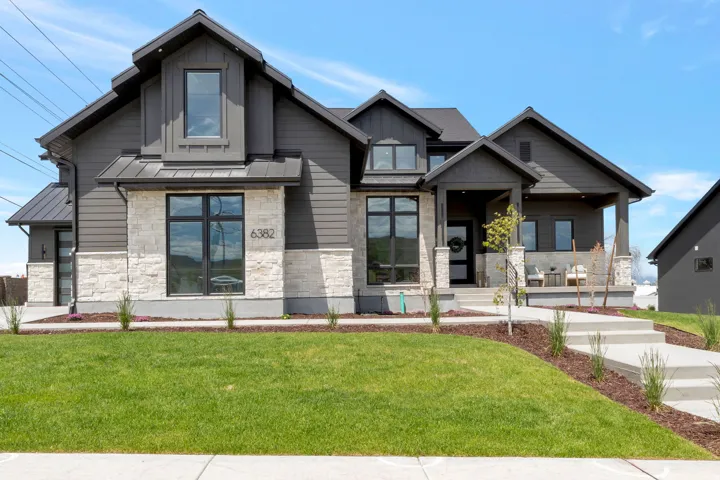 Modern-style home featuring dark gray siding and white stone veneer accents