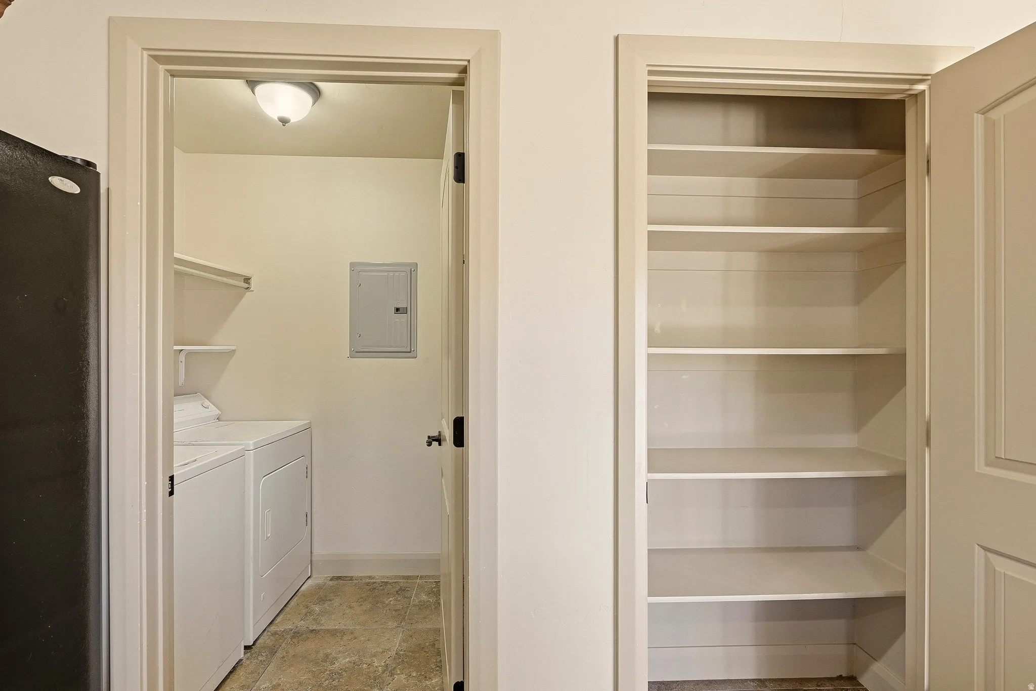 Dedicated laundry area with stone-finish flooring and an overhead light fixture