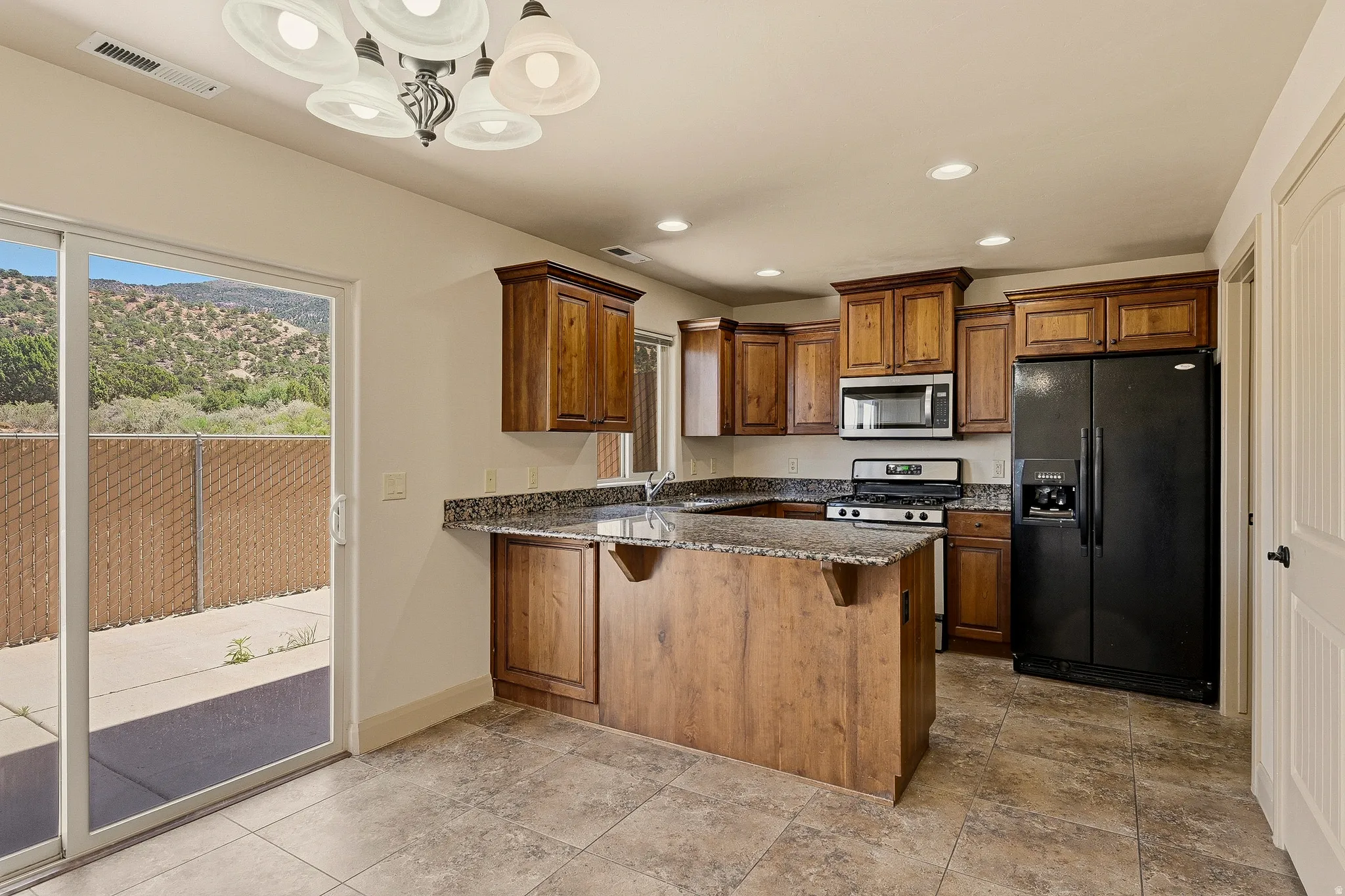 Kitchen featuring wood cabinetry, dark countertops, and stainless steel appliances