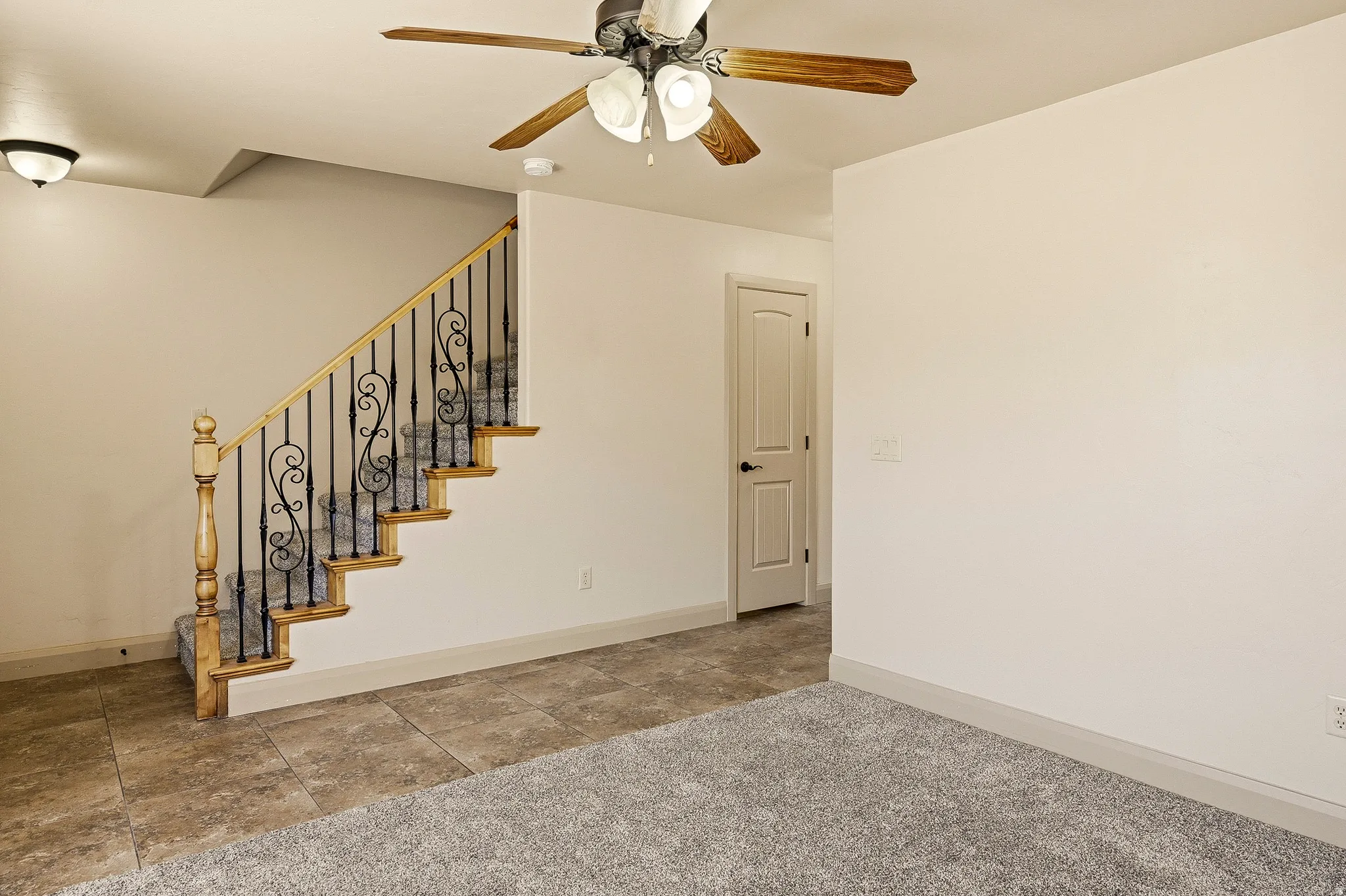 Staircase featuring wood treads and wrought iron spindles