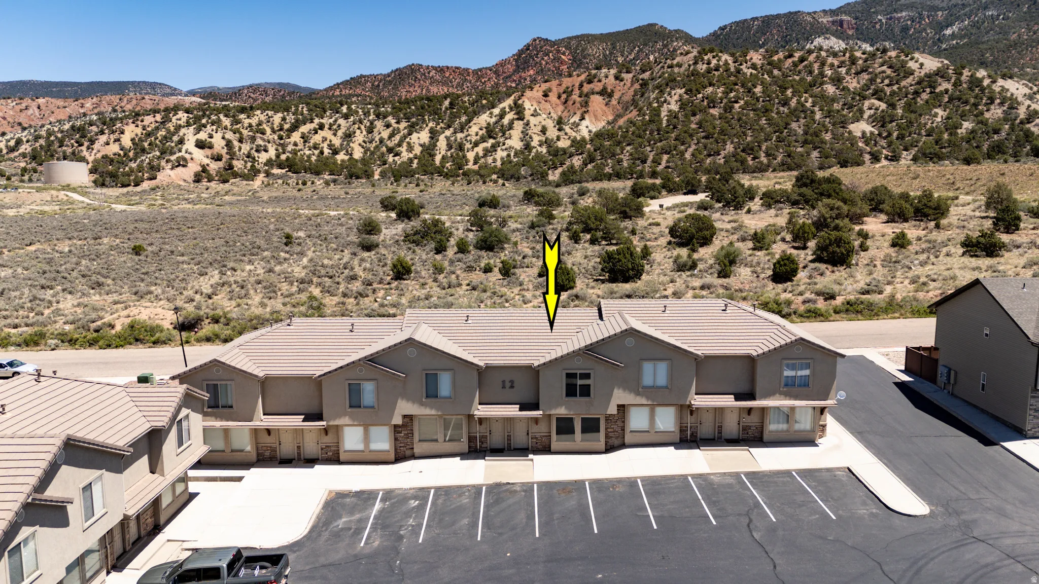 Multi-unit property featuring stucco exteriors with stone accents and tile roofing