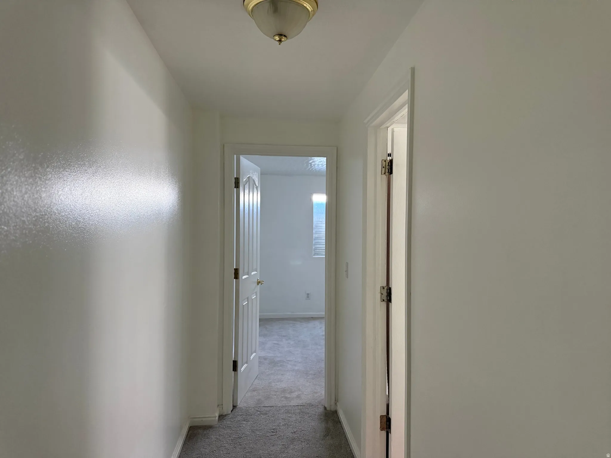 Hallway with neutral wall finishes and a flush mount ceiling light fixture