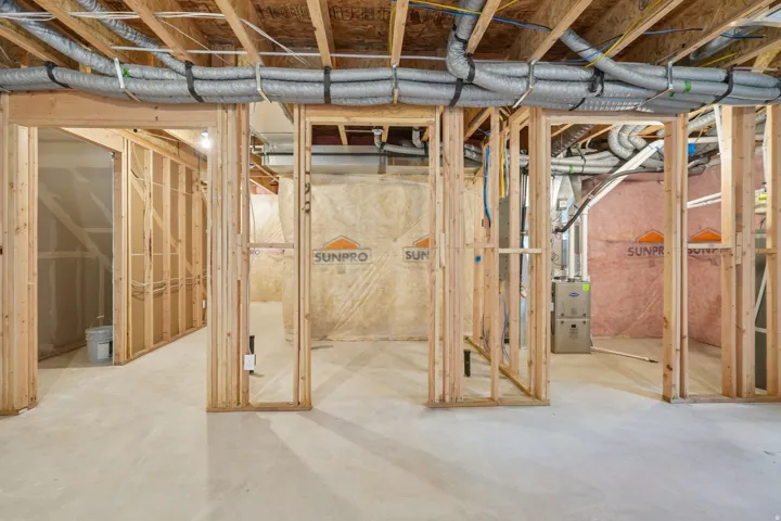 Unfinished basement with exposed wooden framing and concrete flooring