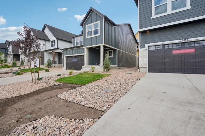 Modern exterior featuring gray siding, a single garage, and concrete driveway