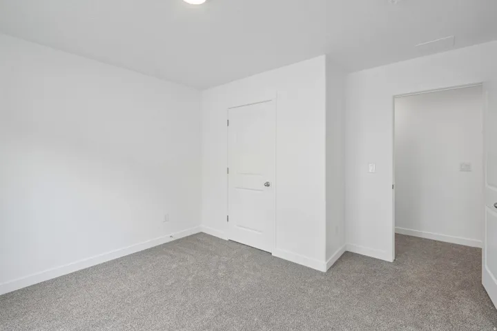 Neutral gray carpeting, white walls, and bright overhead lighting