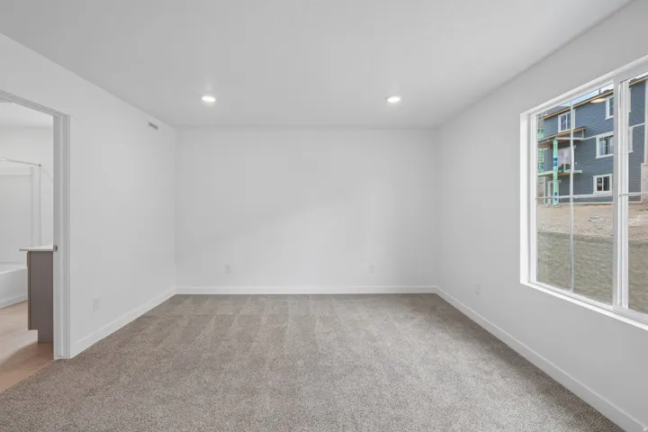 Carpeted flooring, recessed lighting, and a large window