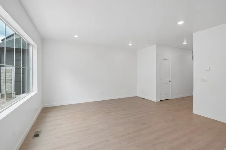 Expansive room featuring wood-finish flooring, recessed lighting, and a large multi-pane window